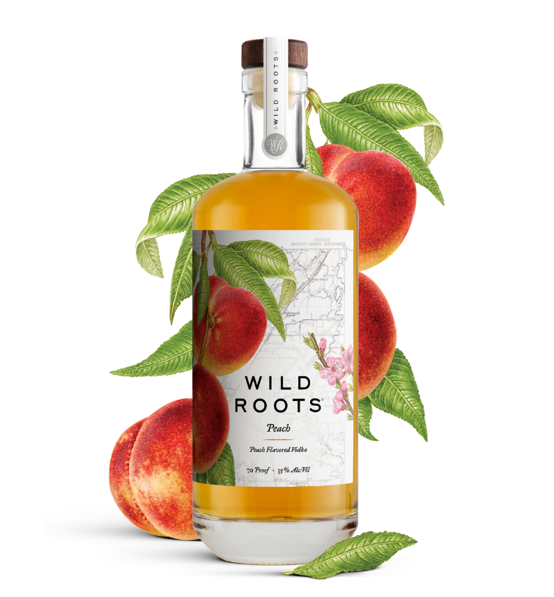 Bottle of Wild Roots Peach vodka with peaches and leaves on a white background